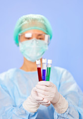 Medical test tube samples in doctor's hand on blue background