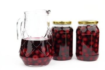 Compote with cherries in jars and ewer