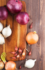 Different varieties of onions on a kitchen board