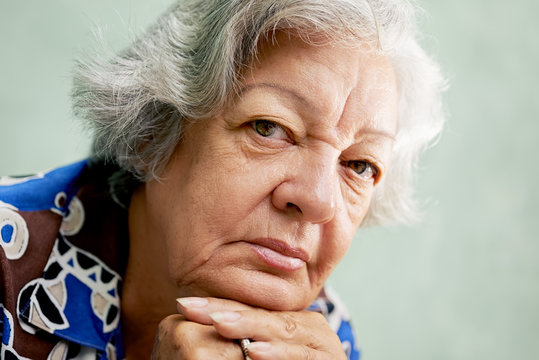 Portrait Of Serious Old Woman Looking At Camera With Hands On Ch