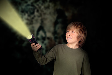 Child with a flashlight looking for something - obrazy, fototapety, plakaty