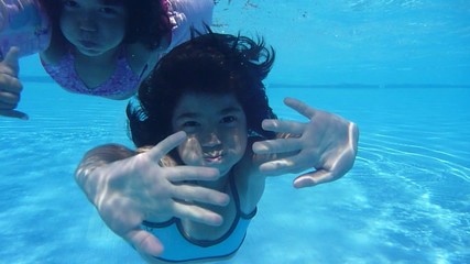 The little girl in the water park swimming underwater