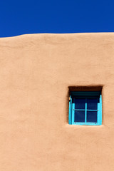 Naklejka premium Blue window on adobe wall