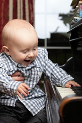 beautiful little baby boy plays piano