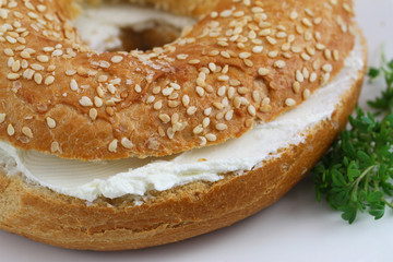 Bagel with cream cheese with watercress garnish, close up
