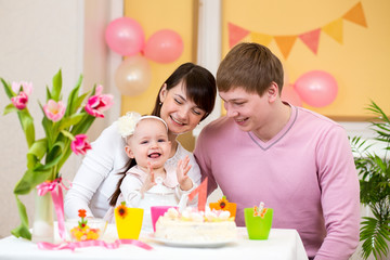 Obraz na płótnie Canvas family celebrating first birthday of baby daughter