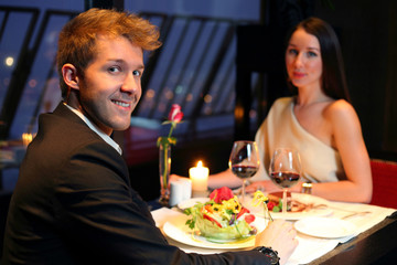 A young boy and a beautiful girl having dinner