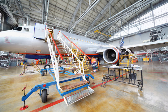 Fototapeta Repairing plane in hangar