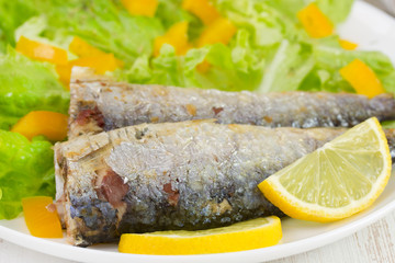 fried fish with lemon and salad