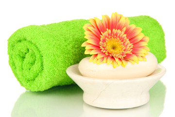 Obraz na płótnie Canvas Rolled green towel, soap bar and beautiful flower isolated