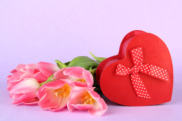 Pink tulips and gift box, on color background