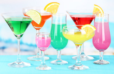 Glasses of cocktails on table near pool