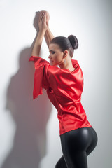 girl posing in red silk tunic and black leggings