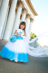 Fototapeta premium Little bride. A girl in a lush white and blue wedding dress and