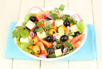Fresh salad in plate on wooden table
