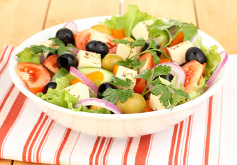 Fresh salad in plate on wooden table