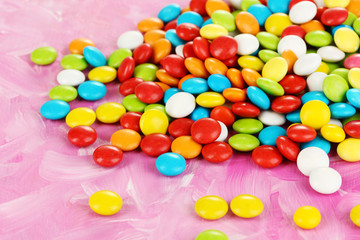 Colorful candies on pink background