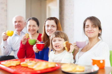 Obraz na płótnie Canvas Szczęśliwa rodzina pije herbatę z ciasta