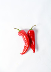 Two red peppers on white background