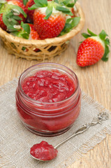 strawberry jam in a glass jar and fresh strawberries