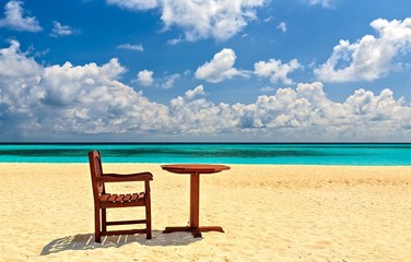 Chairs and  table are on the beach