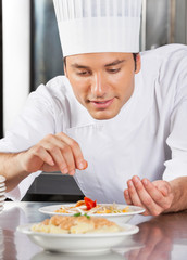 Chef Sprinkling Spices On Dish