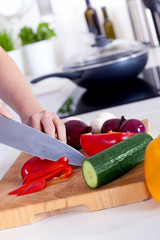 female hands chopping vegetables on a wooden board