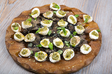 Mozzarella pieces with pesto, basil and olive oil