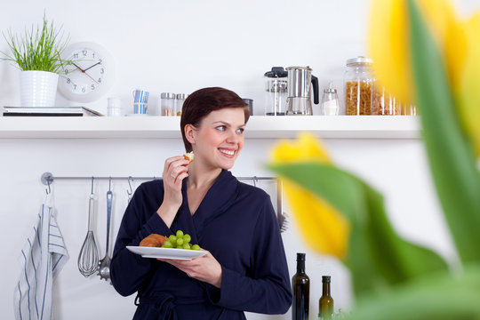 young woman having a healthy breakfast in her kitchen