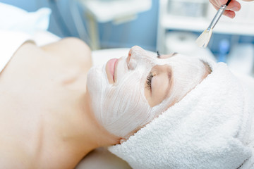 Obraz na płótnie Canvas Woman having facial mask at beauty salon