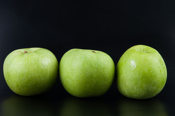 Fresh green apple on black background