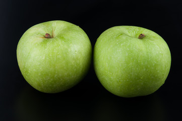 Fresh green apple on black background