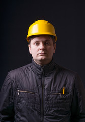 Man with helmet in hand on a black background