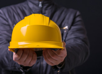 Man with helmet in hand on a black background