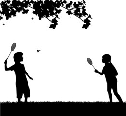 Kids playing badminton outdoor in spring silhouette