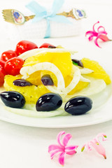 Fresh orange salad and flowers around the plate