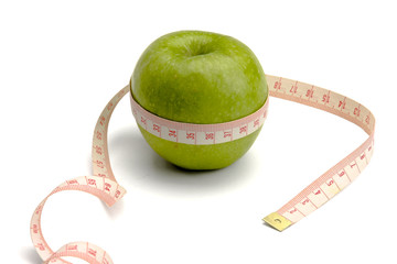 A green apple and a measuring tape, isolated on white background
