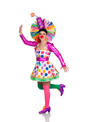 Funny girl clown with a big colorful wig dancing