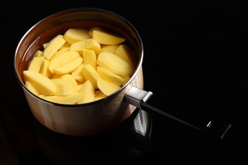 Raw peeled potatoes in pan