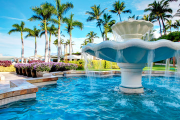 Luxury water fountain in tropial resort with palm trees.