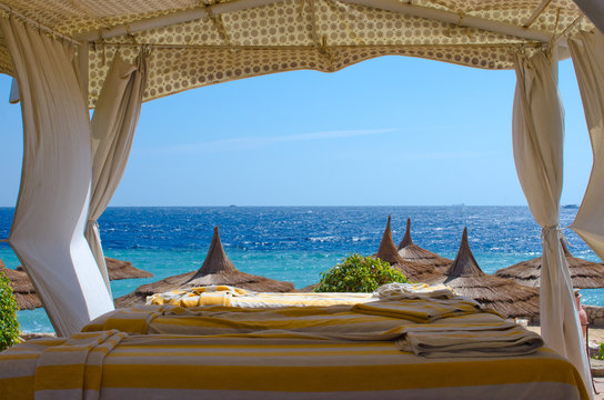 Beach spa gazebo with white canopy, blue sea background