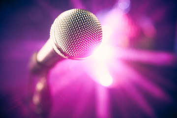 microphone on stage against purple rays background