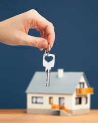 hand holding key against house background