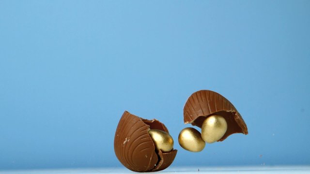 Chocolate easter egg falling against blue background