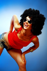 Smiling tanned woman with afro hair posing
