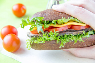 Sandwich of brown bread with beef, cheese and vegetables