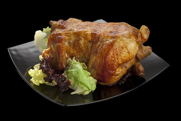 oasted chicken garnished with salad on black background