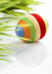 Easter egg with colored wool around it.