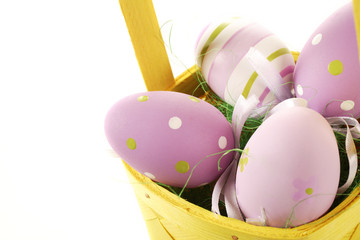 fioletowe jaja wielkanocne w koszyku na białym tle - obrazy, fototapety, plakaty