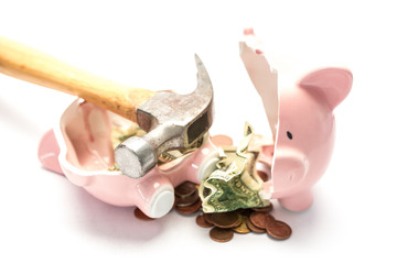 Piggy bank broken with money and hammer